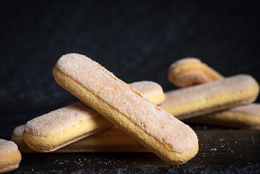 Italian sponges fingers. Italian savoiardi cookies. Ladyfinger cookies o black background
