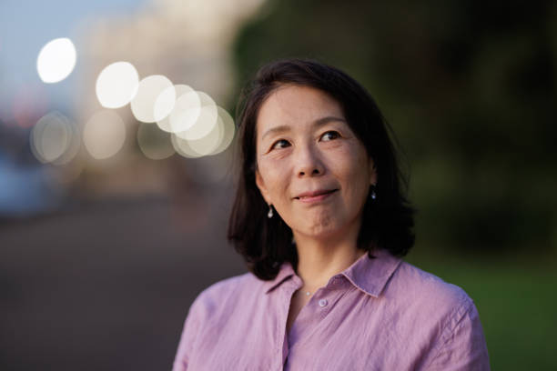 istock Smiling Asian woman outdoors thinking 1513347198