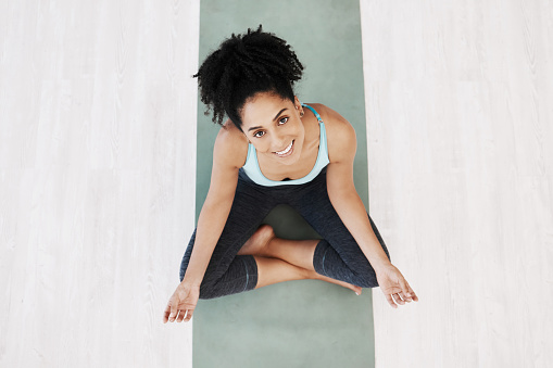 Fitness, yoga and girl portrait top view on ground with mat for wellness, happiness and health. Spirituality, self care and healthy mindset of black woman relaxed on floor for awareness exercise.