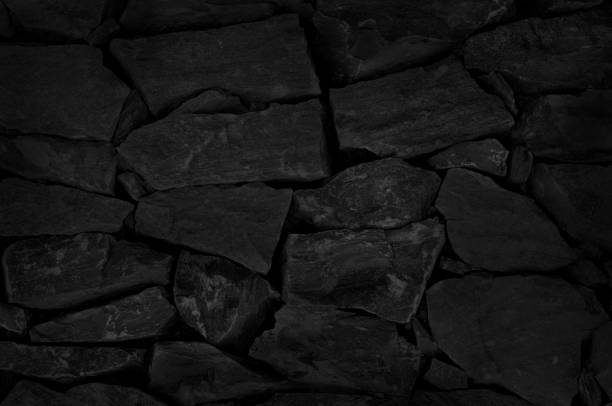 istock Old dark black stone brick wall texture with vintage style for background and design art work. 1513349840