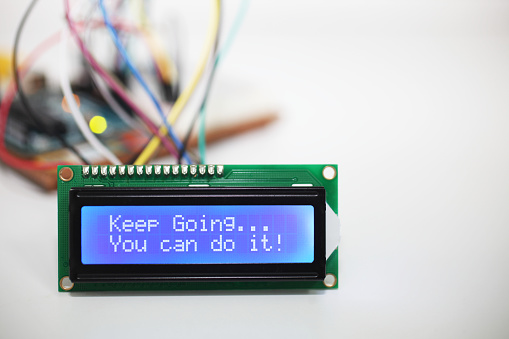 A blue LCD display showing the mantra \