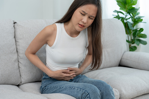 stomach ache. Asian women have abdominal pain, indigestion, gastritis, menstrual cramps, flatulence, diarrhea, distention, colon cancer, belly inflammation problem, suffer food poisoning, abdomen