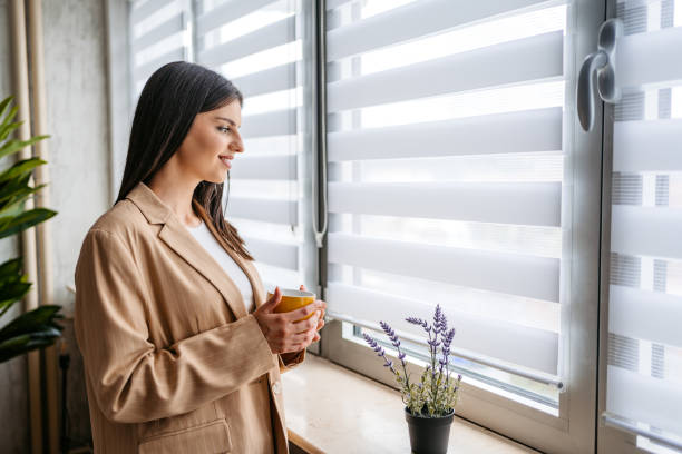 istock Young Woman Standing By The Window And Drinking Coffee 1513413170