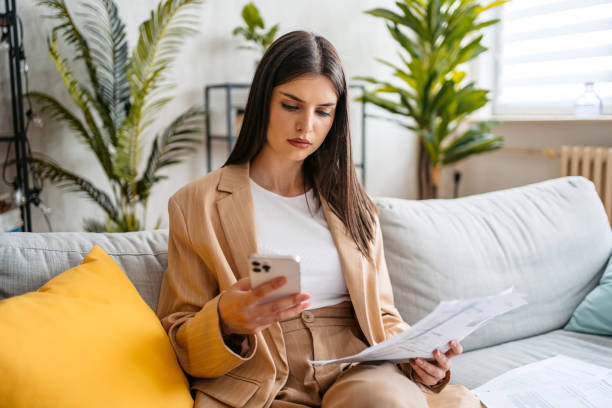 istock Young Woman Checking Her Finances Using Smart Phone At Home 1513415704