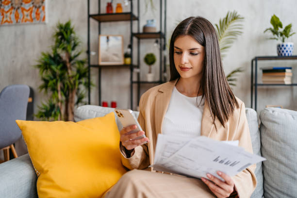 istock Young Woman Checking Her Finances Using Smart Phone At Home 1513420183
