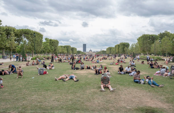 vue extérieure des personnes qui traversent la canicule pendant les journées les plus chaudes de l’été dans le parc du champs de mars. - resting place photos et images de collection