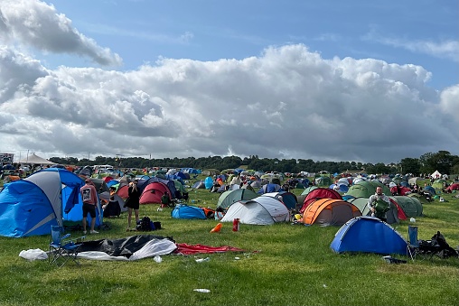 Glastonbury Festival, Pilton, Somerset, UK - June 26, 2023: One of the crowded campsites on the final day as people pack away and start to leave. Festival goers are encouraged to recycle their trash, respect the land and take everything home with them. Despite this, tents and camping equipment is often abandoned by festival goers.