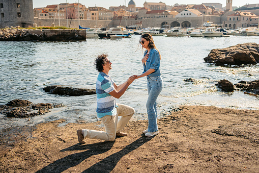 Boyfriend proposing to his girlfriend in Dubrovnik Old Town bay in Croatia.