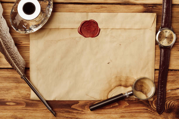 istock Old paper on brown wood background with feather 1513487150
