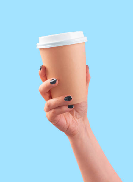 istock Woman's hand holding disposable coffee cup on blue background 1513489975