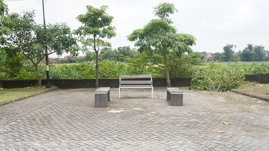 Wooden seating benches in public parks garden. paving areas