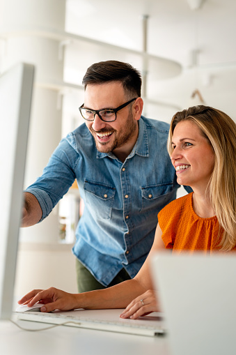 Happy couple doing business together working at small office. People work technology concept.