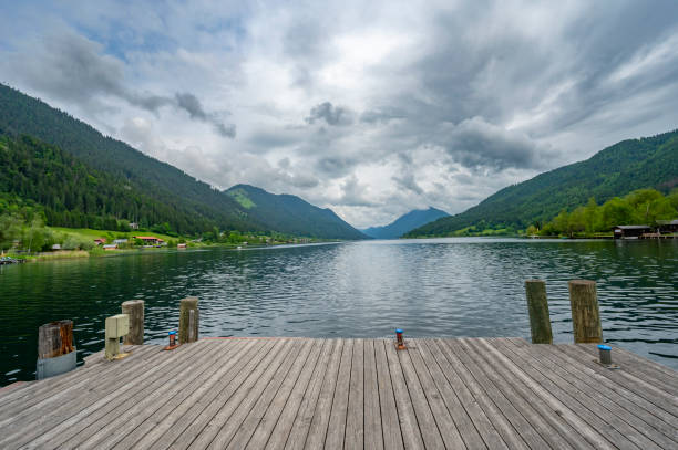 Weissensee or Weißensee lake in Carinthia in Austria within the Gailtal Alps mountain range during an overcast springtime day.