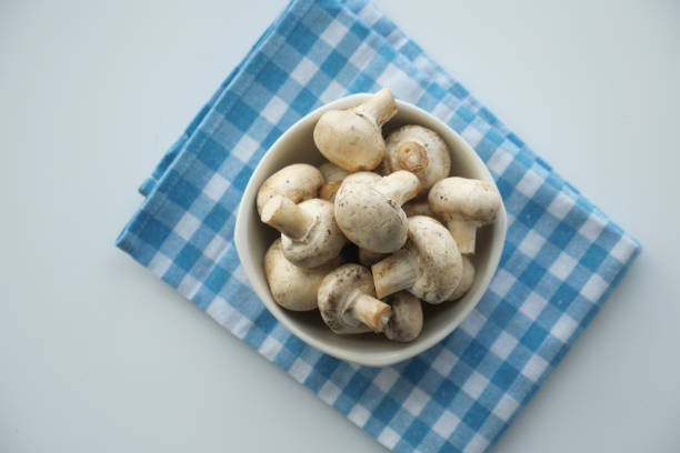 istock Fresh champignons mushroom in a white bowl on table 1513528817