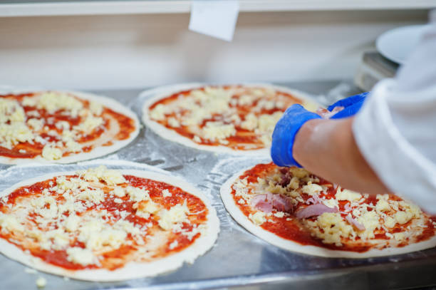 female chef preparing pizza in restaurant kitchen. - pizza sauces chef making imagens e fotografias de stock