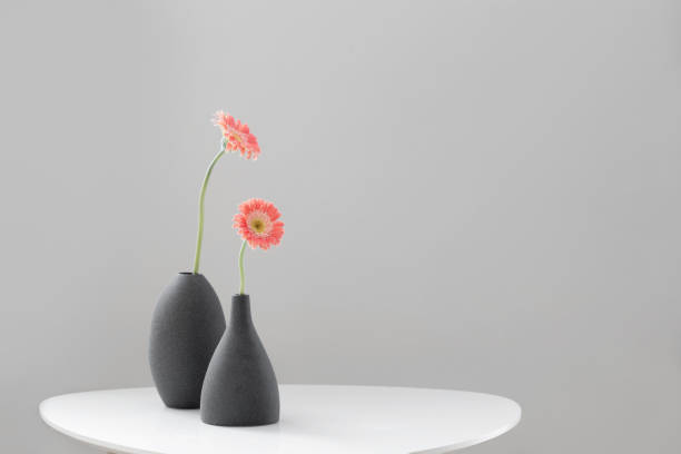 istock pink gerber in gray vases on white table on background gray wall 1513556850