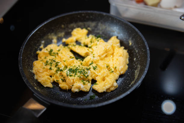 istock Scrambled eggs in cooking pan. Process of cooking scrambled eggs 1513561599