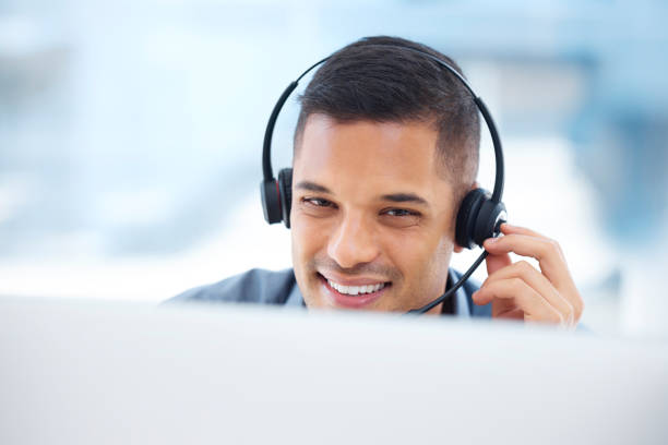 istock Call center, headset or friendly man in communication at telecom customer services on microphone. Smile, crm office or happy sales agent consulting, speaking or talking in technical support help desk 1513565095