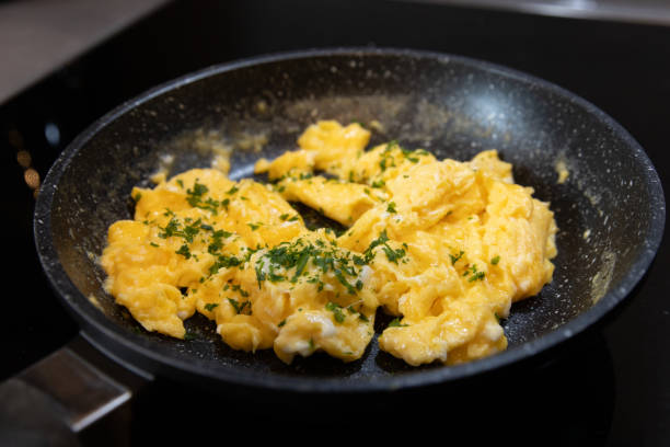 istock Scrambled eggs in cooking pan. Process of cooking scrambled eggs 1513567665