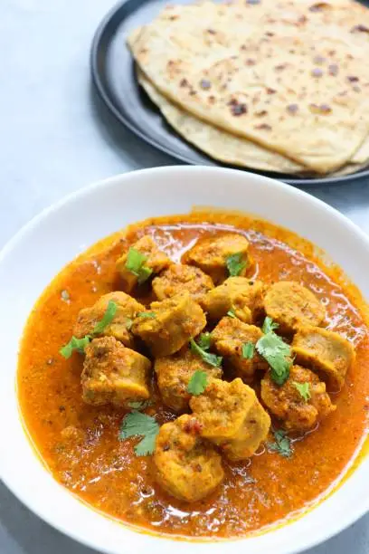 Photo of Rajasthani Gatta Curry or Besan Ke Gatte Ki Sabzi. Gatte are gram flour roundels or chickpea flour dumplings are cooked in a spicy, tangy yogurt based curry. delicacy of Rajasthan, India. copy space.