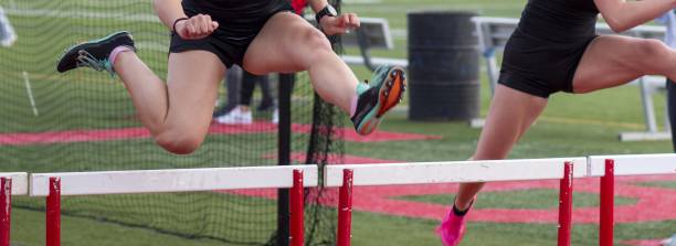 istock Two gilrs running over hurdles during a track hurdle race 1513626242