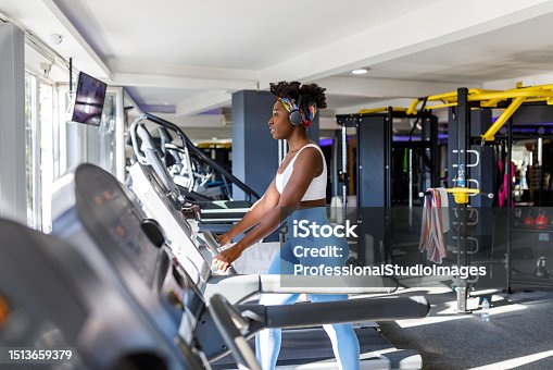istock A beautiful young African sportswoman is listening to music in a gym while running on a treadmill. 1513659379