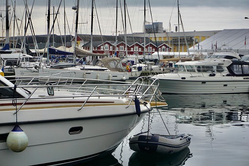 The port of Skagen on a cloudy day. Yachts on the dock are in a row. Reflection in the water of yachts.
