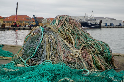 Fishing nets in the port. Fishing nets are laid out on the floor. Colorful fishing nets. Working fishing nets. A mountain of old fishing nets in the port.