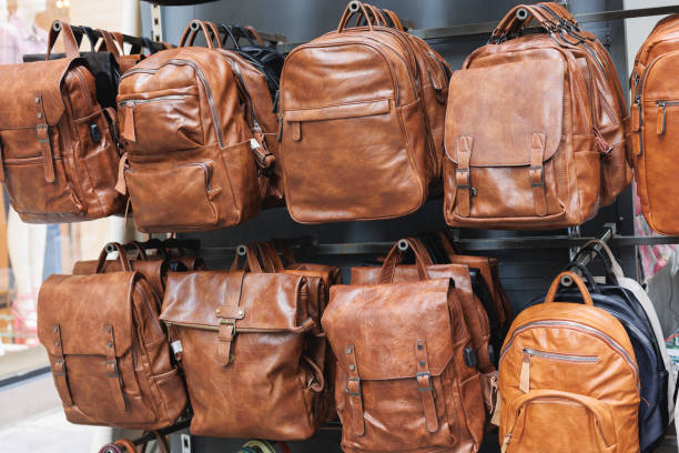 istock Brown Leather Bags and Backpacks Hanging on a Display Stand 1513696514