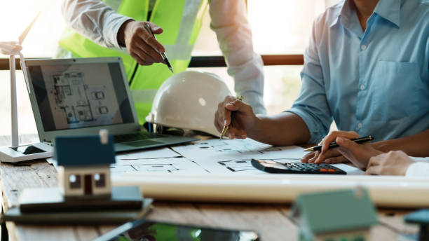 Engineer or architect meeting planning project working together and engineering tools on model building and blueprint in working site. stock photo