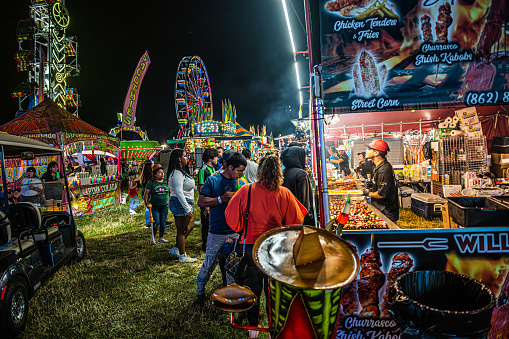 West Windsor, NJ, USA - July  11, 2023: People enjoy the fair food during the L.E.A.D. Festival in West Windsor New Jersey.