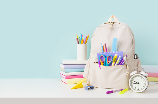 Back to school concept with backpack and stacks of books