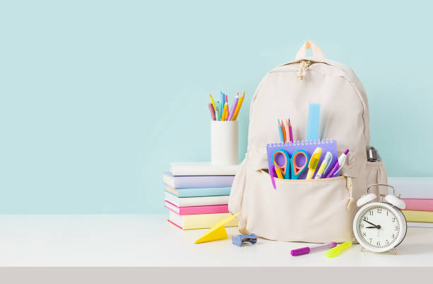 Back to school concept with backpack and stacks of books stock photo