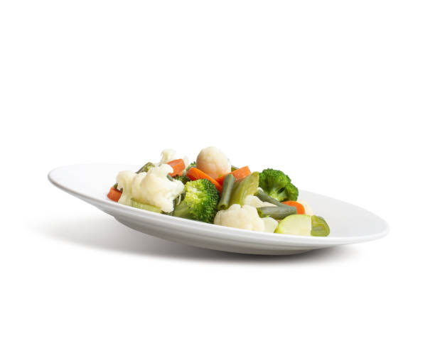 istock steamed vegetables on a white plate on a white background. 1513858362