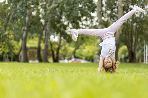 Child making a gymnastics moves at the lawn