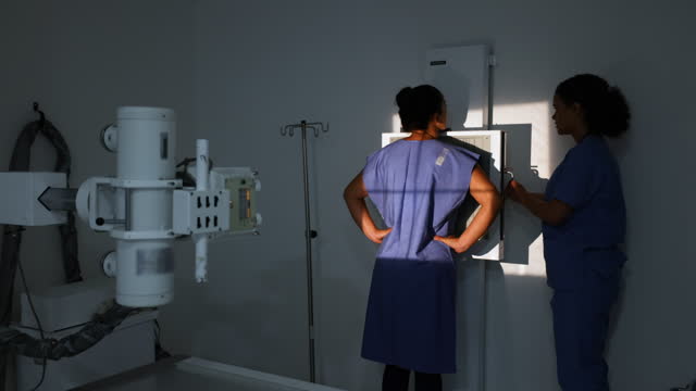 Radiologist getting a female patient ready for an x-ray at the hospital
