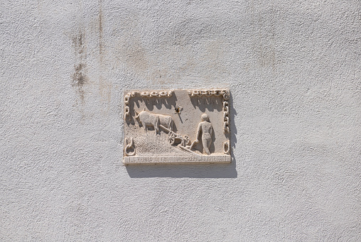 Koper, Slovenia. July 2, 2023. A bas-relief depicting a farmer with a plow on the facade of a building in the city centre