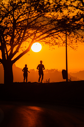 silhouettes of people running during dawn in Rio de Janeiro, Brazil.