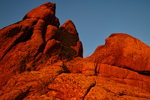 Unusual rocks in a crimson sunset with deep shadows