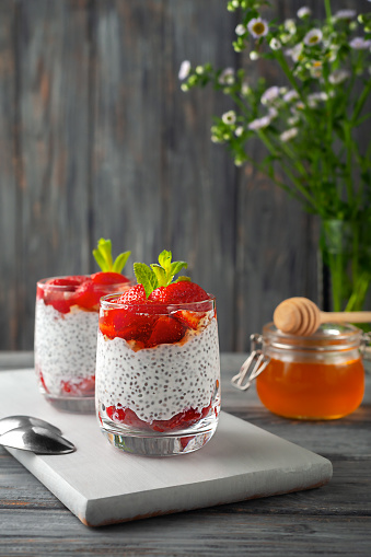 Healthy food. Healthy pudding with chia seeds and strawberries with honey.