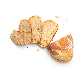 Wheat bread and slices of bread on a white background top view.