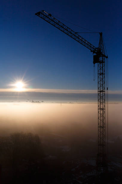 istock Construction crane in the fog at dawn 1514050778