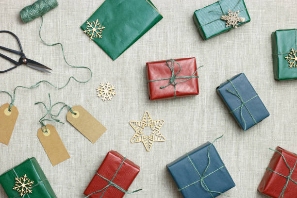 istock Christmas colorful handmade gift boxes on textile background, making green, red paper wrapped xmas presents with jute thread, holiday aesthetic gifts simple craft present, top view table 1514079942