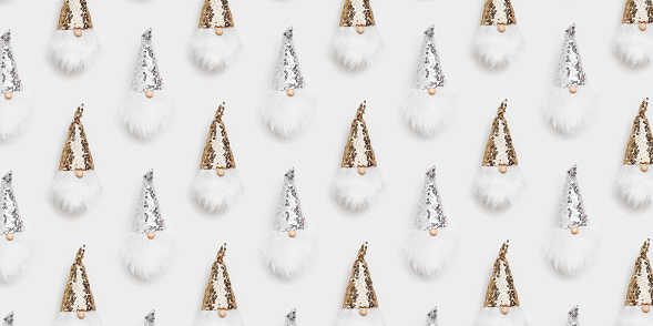 Christmas wide banner. Cute dwarfs with white beard and glittering sequins on cap white background. Christmas, winter, New Year concept. Flat lay, top view wallpaper, minimal holiday trendy pattern