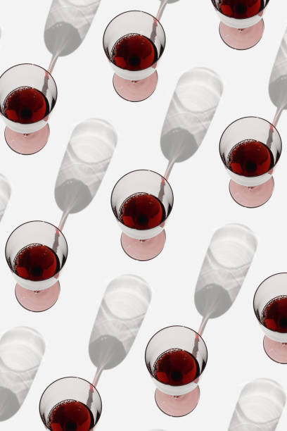 istock Minimal pattern with glasses of red wine with sunlight shadows, Creative summer flat lay. Wine glasses in row on white background geometric layout with alcohol drinks, aesthetic photo, top view 1514116863