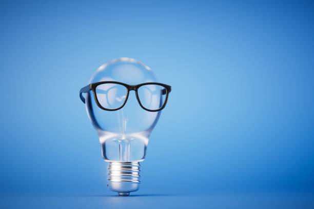 istock generation of good ideas. Electric light bulb with glasses on a blue background. copy paste. 3D render 1514118487