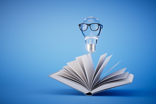 generating ideas after reading the book. A book and a light bulb with glasses on a blue background. 3D render.