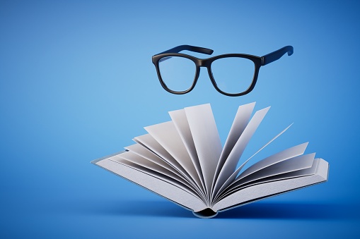 love of reading books. An open book and glasses on a blue background. 3D render.