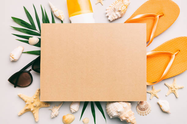 istock Summer time concept with blank greeting card and blank craft paper on colored background. Seashells from ocean shore in the shape of frame separated with space for text top view 1514133530