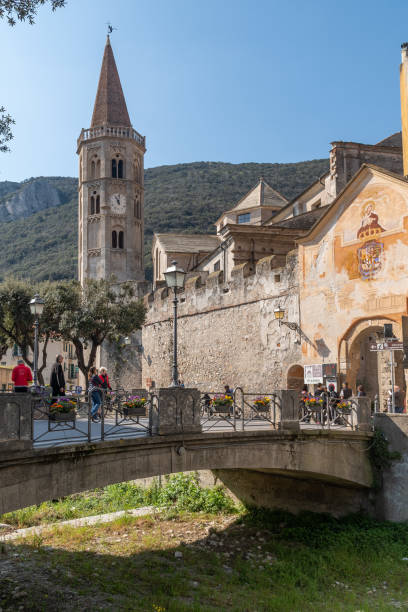 The bridge on the Aquila stream with the bell tower of the church of Saint Biagio and the arch of Porta Reale, one of the medieval gateways to the village, Finalborgo, Finale Ligure, Savona, Liguria, Italy Finalborgo (Finale Ligure), Savona, Liguria, Italy - 04 09 2023 finale ligure stock pictures, royalty-free photos & images